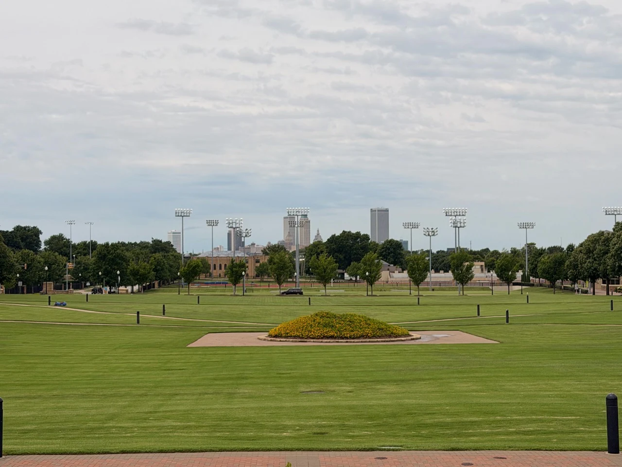Open civic lawn with the downtown Tulsa skyline in the distance