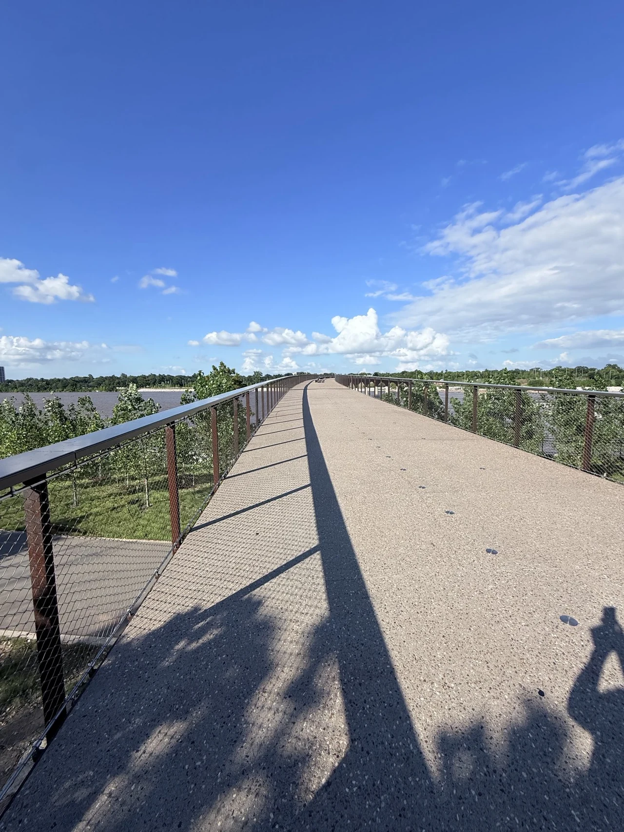 Pedestrian bridge crossing the river beneath a blue sky